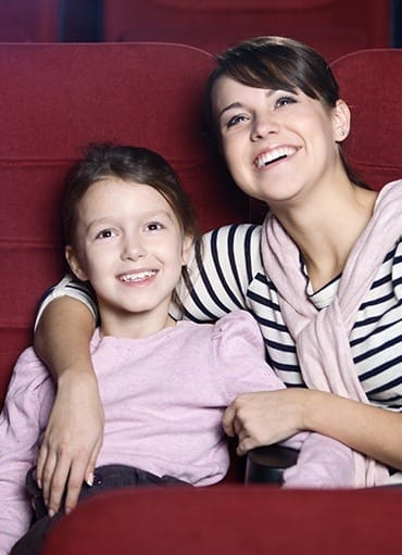 Smiling mother and daughter in theatre
