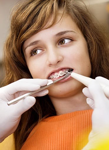 Teen girl having bracket repaired