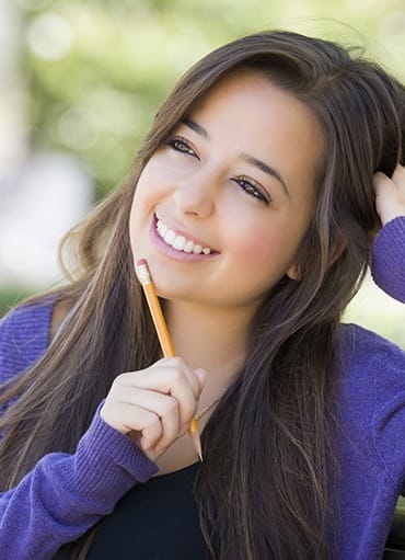 Young girl with pencil thinking