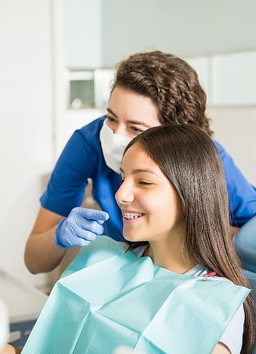 Teen with braces smiling at reflection