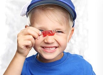 Little boy holding up oral appliance