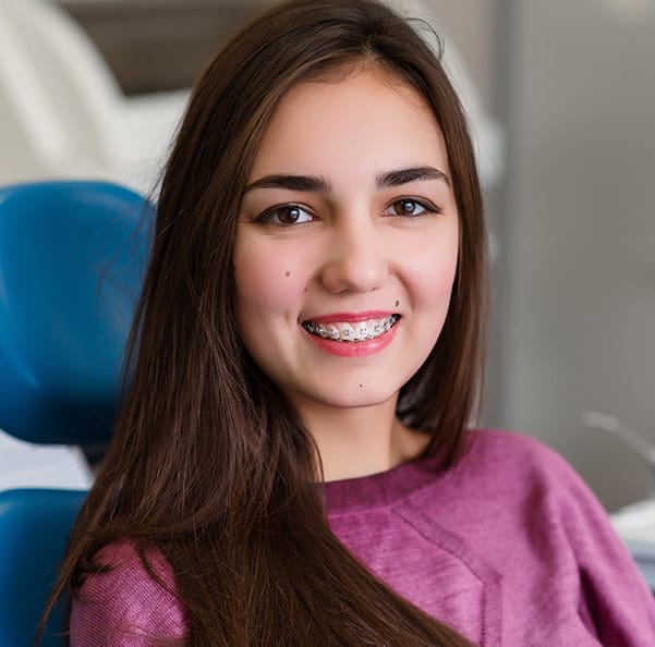 Smiling woman in dental chair with braces