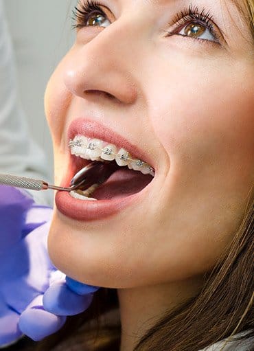 Woman with braces receiving dental exam