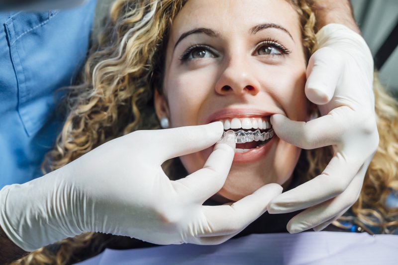 a woman having an Invisalign aligner fitted during an appointment