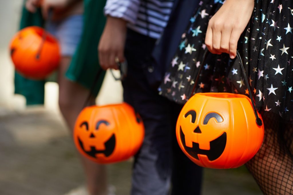 Closeup of children holding jack-o-lantern candy bags