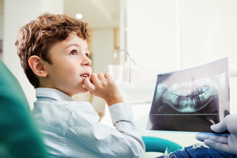 dentist showing child x-rays
